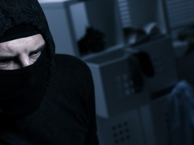 Masked burglar with flashlight